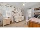 Charming Bedroom showcasing a white crib, dresser, and floral wallpaper at 7708 Foxwood Dr, Raleigh, NC 27615