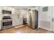 Well-lit kitchen featuring stainless steel appliances, subway tile backsplash, and wood floors at 7708 Foxwood Dr, Raleigh, NC 27615