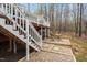 View of stairs leading to a large deck and dining area on pea gravel at 7825 Breckon Way, Raleigh, NC 27615
