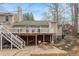 Picturesque backyard with a raised deck, stone patio, and ample greenery for outdoor enjoyment at 7825 Breckon Way, Raleigh, NC 27615