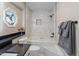 The remodeled bathroom features a tub and shower with marble and mosaic tile at 7825 Breckon Way, Raleigh, NC 27615