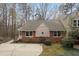 Charming brick home exterior featuring unique architectural details and mature landscaping at 7825 Breckon Way, Raleigh, NC 27615