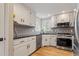 Bright kitchen featuring white cabinets, black countertops, stainless steel appliances, and stylish backsplash at 7825 Breckon Way, Raleigh, NC 27615