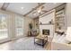 Cozy living room with fireplace, wood beams, ceiling fan, and built-in shelves with decorative wallpaper at 7825 Breckon Way, Raleigh, NC 27615