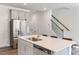 Bright kitchen with a stainless steel refrigerator, island with sink, and a breakfast bar at 812 Windmill Palm Dr, Zebulon, NC 27597