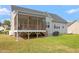 View of the backyard showing raised deck, screened porch, and sprawling green lawn at 8925 Hopkins Knob Ct, Zebulon, NC 27597