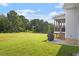 Expansive backyard with verdant lawn and wooded area views, with a concrete patio and grill at 8925 Hopkins Knob Ct, Zebulon, NC 27597