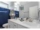 Well-lit bathroom with double sinks, modern fixtures, and a blue shower curtain at 8925 Hopkins Knob Ct, Zebulon, NC 27597