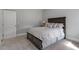 Comfortable bedroom features carpet flooring, gray walls, and a bed with a patterned gray and white comforter at 8925 Hopkins Knob Ct, Zebulon, NC 27597