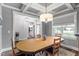 Open dining room with coffered ceilings, chandelier, and view of connected living space at 8925 Hopkins Knob Ct, Zebulon, NC 27597