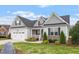Beautiful home showcasing a manicured lawn, two-car garage, and a welcoming front porch, radiating curb appeal at 8925 Hopkins Knob Ct, Zebulon, NC 27597