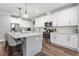 Modern kitchen features stainless steel appliances, wood floors, sleek countertops, and a breakfast bar for casual dining at 8925 Hopkins Knob Ct, Zebulon, NC 27597