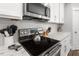 Close-up of a modern kitchen with white cabinets, stainless steel appliances, and white countertops at 8925 Hopkins Knob Ct, Zebulon, NC 27597