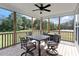 Relaxing screened-in porch featuring a ceiling fan and a dining table with four chairs at 8925 Hopkins Knob Ct, Zebulon, NC 27597