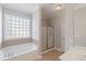 Bathroom showcasing a soaking tub, tiled shower, and natural light from a window at 912 Sethcreek Dr, Fuquay Varina, NC 27526