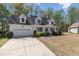 View of the exterior of a home with white siding, black shutters, and a driveway leading to an attached garage at 912 Sethcreek Dr, Fuquay Varina, NC 27526