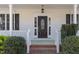 Front door with glass insert and sidelights framed by greenery on a white, covered porch at 912 Sethcreek Dr, Fuquay Varina, NC 27526