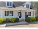 Close up of the front porch with white railings, black shutters, brick steps, and an oval glass front door at 912 Sethcreek Dr, Fuquay Varina, NC 27526