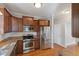 Well-lit kitchen featuring stainless steel appliances, granite countertops, and wood cabinets at 912 Sethcreek Dr, Fuquay Varina, NC 27526