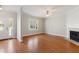 Open living space with hardwood floors, a fireplace, a ceiling fan, and a window with view to the front yard at 912 Sethcreek Dr, Fuquay Varina, NC 27526