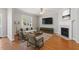 Bright living room with hardwood floors, a fireplace, a ceiling fan, and a large window at 912 Sethcreek Dr, Fuquay Varina, NC 27526