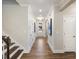 Well-lit hallway with hardwood floors, leading to a bright entry and featuring stairs at 929 Thimbleweed Way, Wake Forest, NC 27587