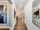 Inviting hallway featuring hardwood floors, decorative mirrors and paintings leading to the living areas at 929 Thimbleweed Way, Wake Forest, NC 27587