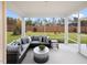 Inviting screened patio featuring a cozy sectional and view of the landscaped backyard at 929 Thimbleweed Way, Wake Forest, NC 27587