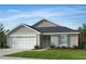 Charming single-story home featuring neutral siding, black roof, two-car garage, and professionally landscaped yard at 100 Chestnut Oak Ln, Lillington, NC 27546