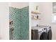 Stylish bathroom featuring a mosaic-tiled shower and modern washer and dryer appliances at 1008 North St, Durham, NC 27701