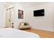 A bedroom with hardwood floors, a chair, and a mounted TV at 1008 North St, Durham, NC 27701