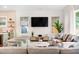 A living room with hardwood floors, neutral furniture, and a mounted television at 1008 North St, Durham, NC 27701