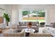 A living room with hardwood floors, neutral furniture, and a view of the backyard at 1008 North St, Durham, NC 27701