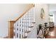 View of the staircase with wooden rails, white spindles, and entryway decor on the side wall at 1008 North St, Durham, NC 27701