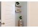 Small toilet room with neutral decor, wooden shelves and plants at 1008 North St, Durham, NC 27701