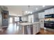 Open-concept kitchen featuring stainless steel appliances, white cabinetry, and a view of the dining and living area at 11 Balboa Pkwy, Clayton, NC 27520