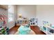 Bright playroom with hardwood floors, a blue table with chairs, and several toy kitchen sets at 11 Balboa Pkwy, Clayton, NC 27520