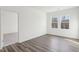 Bedroom featuring hardwood floors, two windows, and a doorway leading to another room at 112 Oat Grain Ct, Clayton, NC 27520