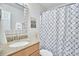Well-lit bathroom featuring granite vanity, shower with patterned curtain, and decorative Biltmore print at 1120 N Roxboro St, Durham, NC 27701