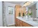 Bathroom featuring double sink, wood cabinet, granite countertop, and large well lit mirror at 1120 N Roxboro St, Durham, NC 27701