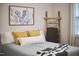 Bright bedroom with a cozy bed, decorative ladder, and eye-catching cactus artwork above the bed at 1120 N Roxboro St, Durham, NC 27701