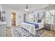 Well-lit main bedroom with wood flooring, white walls, a ceiling fan, light-blocking curtains, and ensuite bathroom at 1120 N Roxboro St, Durham, NC 27701