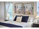 Bedroom featuring cozy bedding, decorative pillows, bedside tables, and large windows for ample natural light at 1120 N Roxboro St, Durham, NC 27701