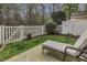 Inviting backyard showcasing a patio lounge area, a well-manicured lawn, and a classic white picket fence at 11251 Lofty Heights Pl, Raleigh, NC 27614