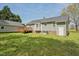 Large backyard with green grass, a wood deck, and a grey house with a detached garage at 114 Marshay Meadow Rd, Youngsville, NC 27596