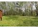 Large backyard with a lush green yard and surrounded by tall mature trees at 114 Marshay Meadow Rd, Youngsville, NC 27596