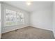 This bedroom has neutral carpet, white walls, and a large window that lets in plenty of natural light at 114 Marshay Meadow Rd, Youngsville, NC 27596