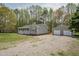 View of the single-story home's exterior, featuring a detached garage and a spacious gravel driveway at 114 Marshay Meadow Rd, Youngsville, NC 27596