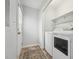 Convenient laundry room with white washer and dryer, shelving, and access to the outdoors at 114 Marshay Meadow Rd, Youngsville, NC 27596
