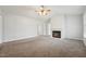 Open-concept living room featuring neutral carpet and a cozy fireplace, bathed in natural light at 114 Marshay Meadow Rd, Youngsville, NC 27596